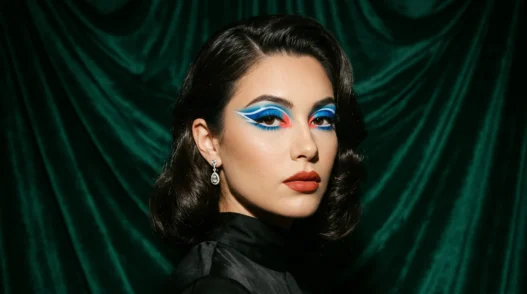 Woman with bold baddie makeup featuring graphic color blocking and dramatic festival-ready styling