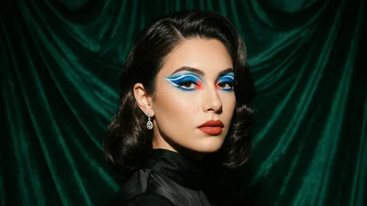 Woman with bold baddie makeup featuring graphic color blocking and dramatic festival-ready styling