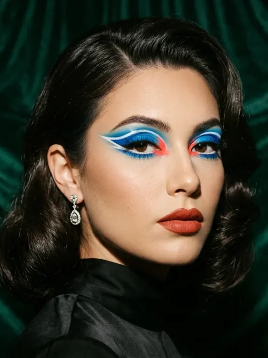 Woman with bold baddie makeup featuring graphic color blocking and dramatic festival-ready styling