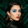 Woman with bold baddie makeup featuring graphic color blocking and dramatic festival-ready styling