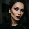 Woman with complete dark feminine makeup featuring smoky charcoal eyes and wine-toned lips