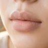 Close-up of lips with smooth matte primer applied showing even texture and preparation
