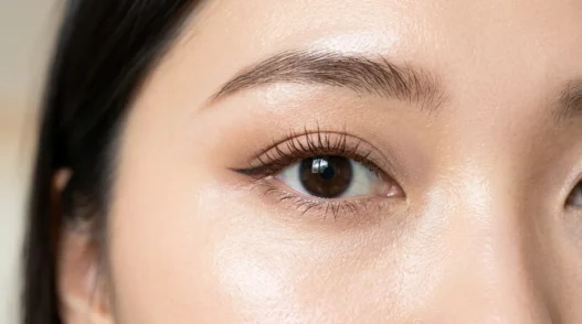 Close-up of eye area showing ABG makeup with dewy skin finish and brown mascara on natural lashes