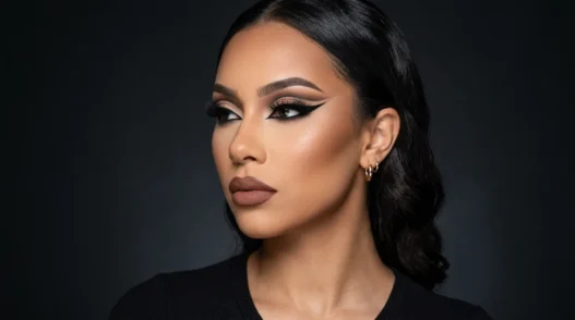 Model wearing complete baddie makeup look with sharp winged eyeliner and sculpted contour in three-quarter profile view