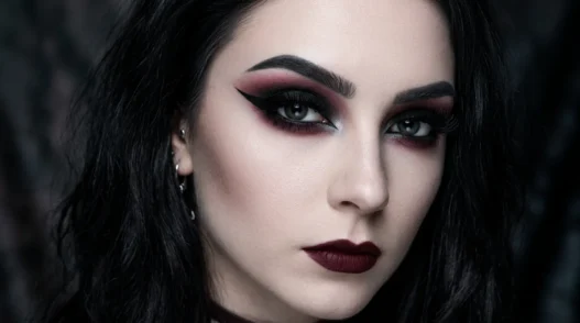 Complete gothic eye makeup look with smoky black eyeshadow, burgundy undertones, and sharp winged eyeliner on pale skin
