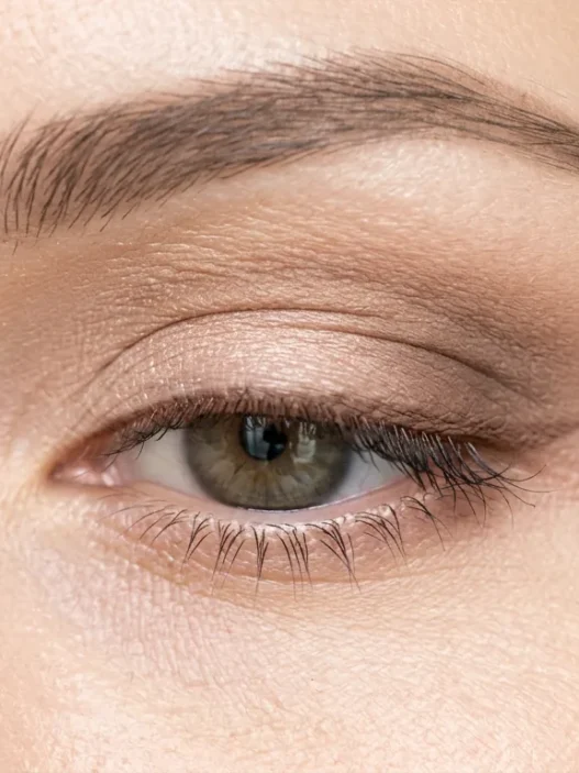 Close-up of one eye during makeup tutorial showing application technique in bright even lighting
