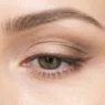 Close-up of one eye during makeup tutorial showing application technique in bright even lighting