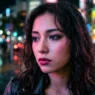Woman with makeup on city street at night with colorful neon lighting creating pink and blue reflections