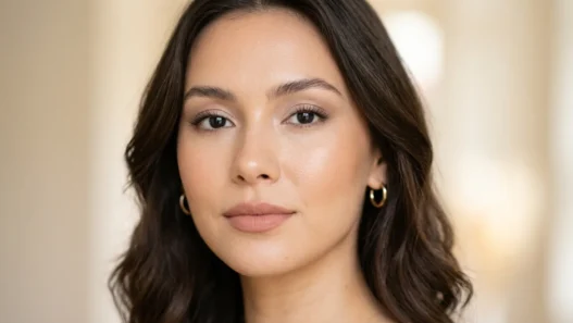 Woman with polished neutral makeup showing soft brown eyeshadow and natural pink lips in editorial portrait