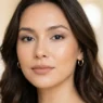 Woman with polished neutral makeup showing soft brown eyeshadow and natural pink lips in editorial portrait