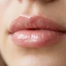 Close-up of lips with perfect high-shine clear gloss showing smooth even application and glass-like finish
