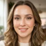 Woman with soft glam makeup featuring peachy-pink tones and dewy skin photographed in natural light
