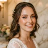 Woman with glossy summer wedding makeup featuring peachy bronze tones in luxurious powder room setting