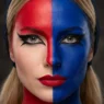 Woman wearing full Harley Quinn makeup with sharp red and blue face split and bold red lips in studio lighting