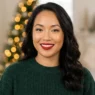 Woman wearing soft gold eyeshadow and red lipstick with glowing skin in holiday setting