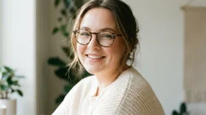 Woman with round face wearing tortoise glasses showing soft sculpted makeup in window light