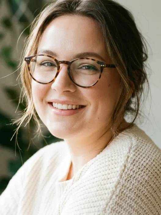 Woman with round face wearing tortoise glasses showing soft sculpted makeup in window light