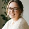 Woman with round face wearing tortoise glasses showing soft sculpted makeup in window light