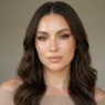 Woman with glassy dewy skin and mirror-shine nude lips in soft daylight