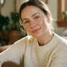 Woman with sheer natural makeup and dewy glowing skin in soft morning window light