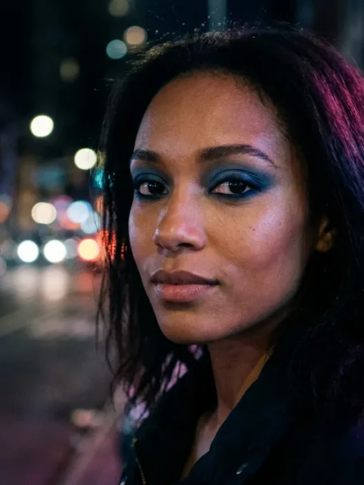 Woman with smoky denim blue eyeshadow and navy liner in neon night street glow