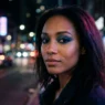 Woman with smoky denim blue eyeshadow and navy liner in neon night street glow