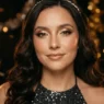Woman wearing glowing New Years Eve makeup with champagne eyes in party bokeh light