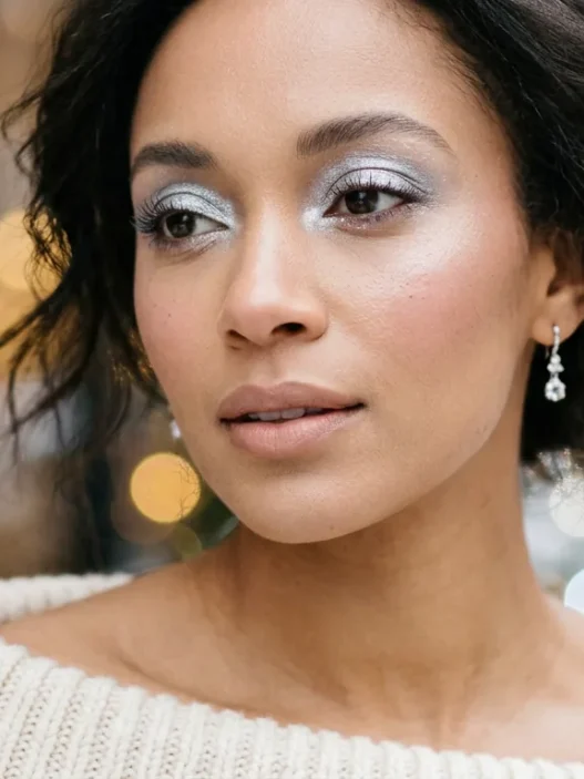 Woman with frosty silver eyeshadow and nude lips in soft warm light